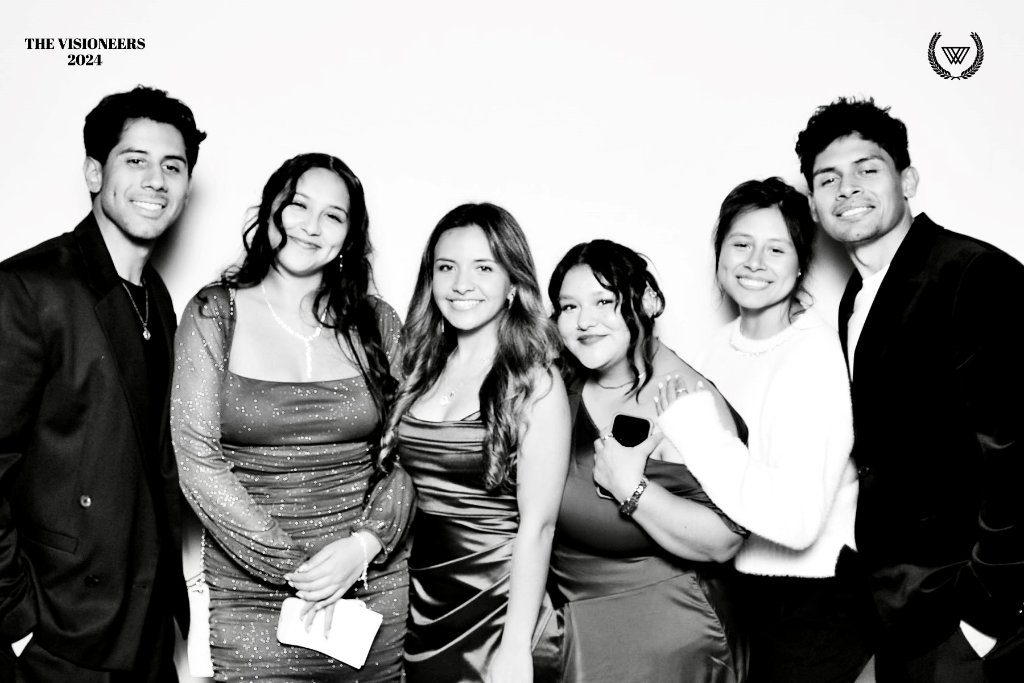 Group of friends posing in a black and white glam booth photo